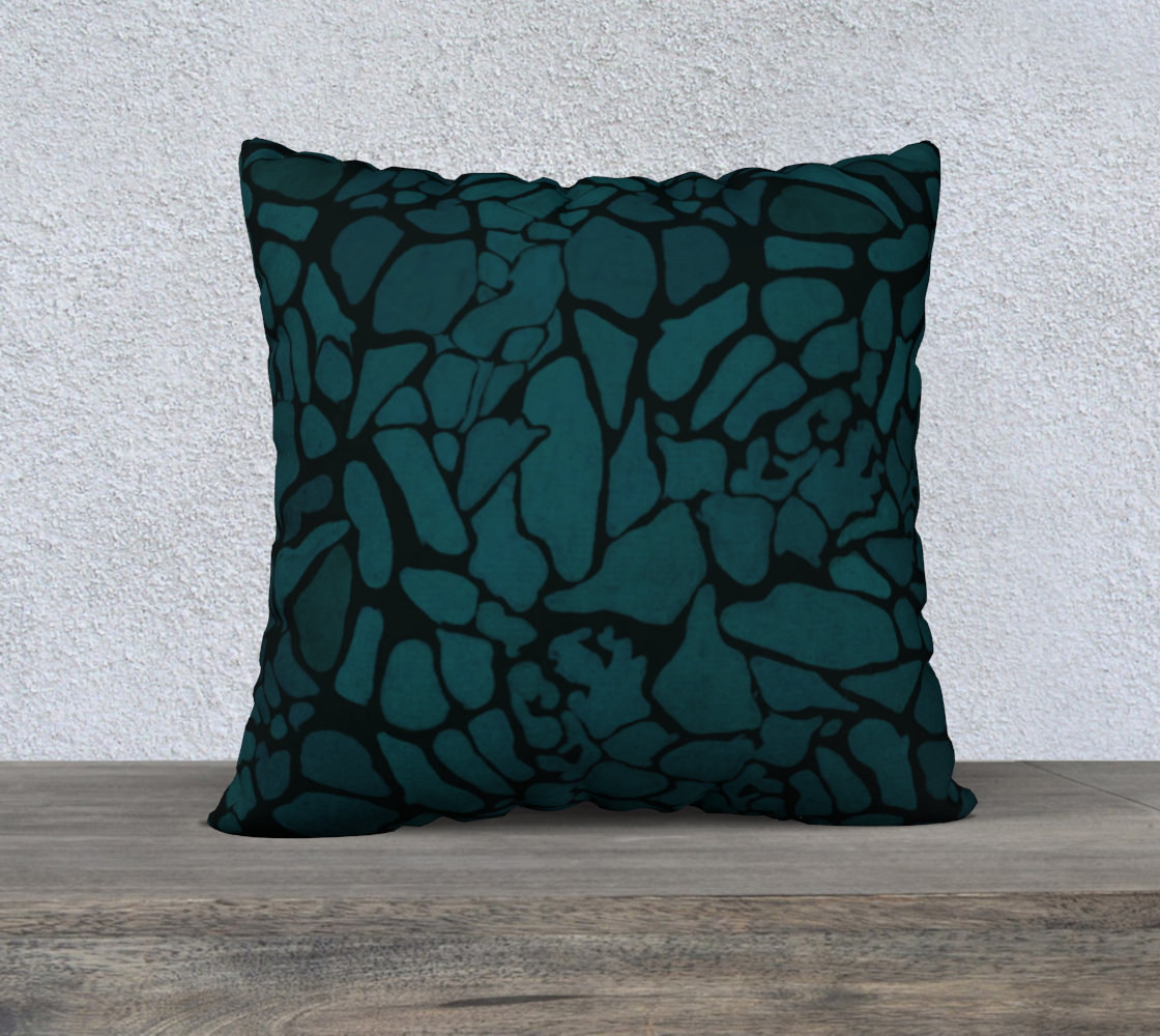 Decorative pillow with abstract pattern on a wooden surface and light gray wall background