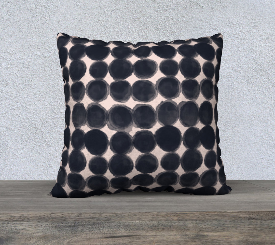 Decorative pillow with black dot pattern on a neutral background