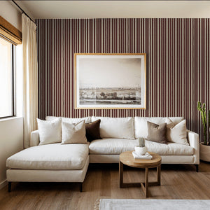 Maroon striped wallpaper in elegant living room with white sofa and framed art.